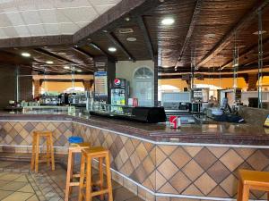 レケナにあるArea de servicio El Rebollarのカウンターのスツール付きバーがあるレストラン