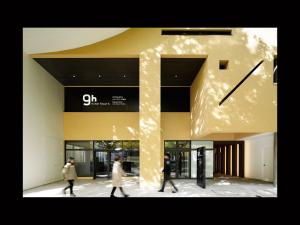 two people walking in front of a building with a clock at 9h nine hours Sendai in Sendai