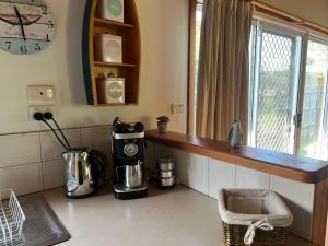 a kitchen with a counter with a coffee maker and a window at Homey Beach Cottage with Spa, walk to beach in Cowes