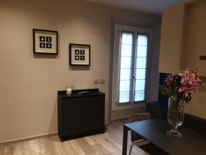 a living room with a table and a vase of flowers at Casa delle Farfalle in Bologna