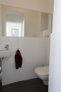 biała łazienka z toaletą i umywalką w obiekcie Casa Nostra - Sonnige Wohnung direkt am Augarten w Wiedniu