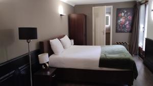 een slaapkamer met een groot wit bed en een lamp bij The Velvet Lodge in Den Haag