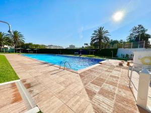 a large swimming pool in a yard with palm trees at Villa Corazon in Torrevieja