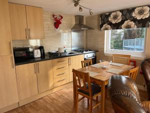 a kitchen with a wooden table and a dining room at Red Deer Village Holiday Park - 3 Bedroom, Self-Catering Chalet in Steps