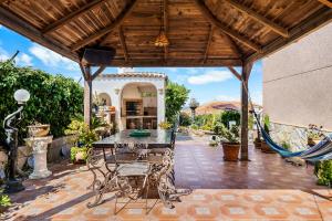 a patio with a table and chairs under a wooden roof at Casa Starlite Sunrise in Almoradí