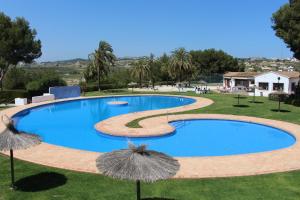 a large swimming pool with umbrellas in a yard at Villa Estrella de Mar in Moraira