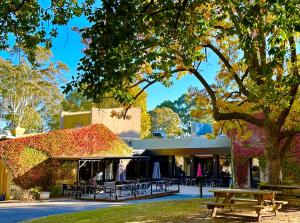 a building with a picnic table and a tree at The Grand Oaks in Beechworth