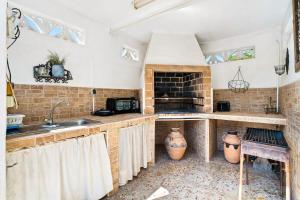 a kitchen with a brick fireplace and a sink at Casa Starlite Sunrise in Almoradí +16 photos