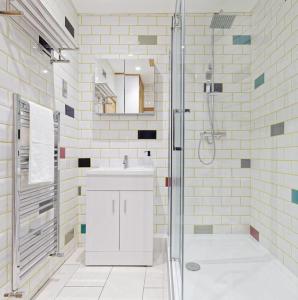 a white bathroom with a sink and a shower at Ramsgate Harbour Retreat in Kent