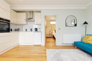 a kitchen and a living room with a blue couch at Ramsgate Harbour Retreat in Kent +6 photos