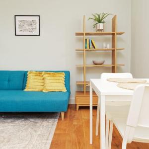 a living room with a blue couch and a table at Ramsgate Harbour Retreat in Kent