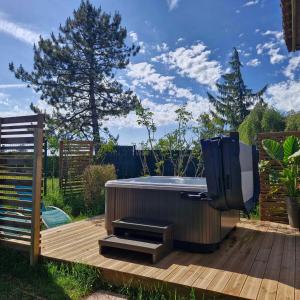 a hot tub and a tv sitting on a deck at Chalet JACUZZI/spa privatif PERCE NEIGE in Plombières-les-Bains