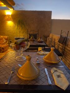 a table with yellow plates and utensils on a table at La Maison Berber Shams in Marrakech