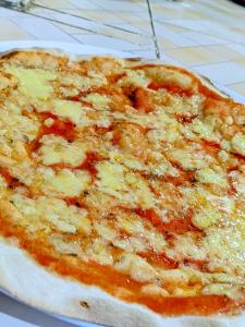 una pizza de queso sentada sobre una mesa en Chambre d'hôte Ristorante Pizzeria Liberta, en Ranohira