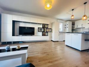 アンジェにあるCasa Bellaの白いキャビネットと薄型テレビ付きの広いキッチンが備わります。