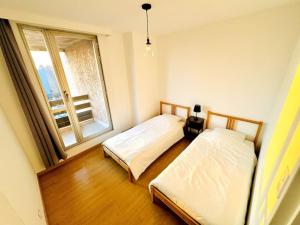 two beds in a room with a window at Casa Luciano in Dunkerque