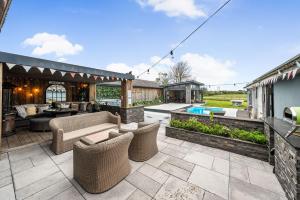 an outdoor patio with furniture and a swimming pool at Deer Lodge in Lymington