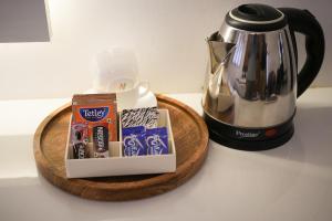 a table with a tea pot and a tray of food at Livora Residency in Chennai