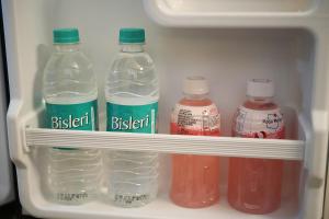 a refrigerator filled with bottles of water and juice at Livora Residency in Chennai +26 photos