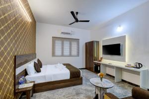 a hotel room with a bed and a tv at Livora Residency in Chennai