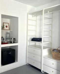 a white closet with white shelves and a tv at Habitación de invitados Casa Lume in Tahiche