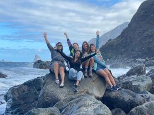a group of girls sitting on a rock on the beach at Casanaga in Almáciga +37 photos