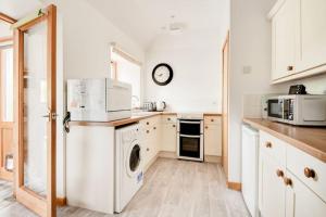 a kitchen with a washer and dryer at Foulis Cottage, Foulis Estate, Highland Scotland in Ardullie