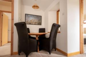 a dining room with a wooden table and black chairs at Foulis Cottage, Foulis Estate, Highland Scotland in Ardullie +27 photos