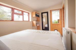 a large white bed in a room with windows at Foulis Cottage, Foulis Estate, Highland Scotland in Ardullie