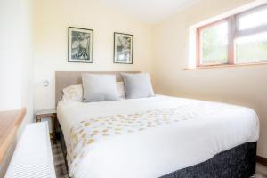 a large white bed in a room with a window at Foulis Cottage, Foulis Estate, Highland Scotland in Ardullie