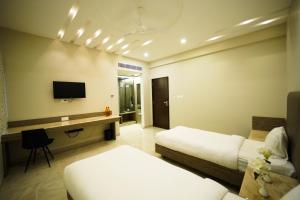 a hotel room with two beds and a television at Sun Shine Hotel in Bengaluru +11 photos