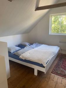 a bed sitting in a room with a window at Ferienwohnung auf dem Bauernhof in Mariannelund