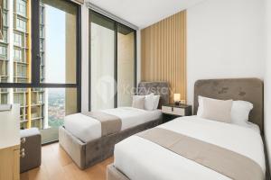 two beds in a room with a large window at Dorado by Kozystay - Cilandak in Jakarta +35 photos