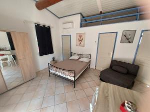 a living room with a bed and a couch at 3 logements jusqu'à 11 personnes LE BARCARES plage et village de noel à pied in Le Barcarès