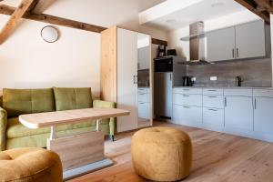 a kitchen with white cabinets and a table and stool at Zimmer An der Wasserburg in Thallwitz