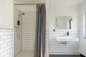 een witte badkamer met douche en wastafel bij rugs HOTEL Köln in Keulen
