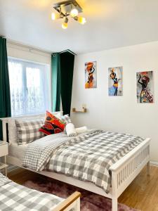 a bedroom with two beds and a window at The Express Apartment in Goodmayes