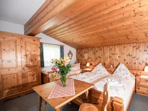 a room with a bed and a table with flowers on it at Present apartment in Fusch in Fusch an der Glocknerstraße