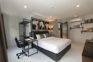 Un dormitorio con una cama, un escritorio y una computadora. en WiRE BANGKOK PRAKHANONG, en Amphoe Phra Khanong