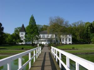 a bridge in front of a white house at Attractive apartment in Westerstede in Westerstede