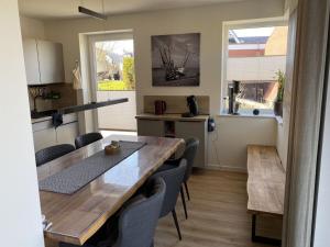 a kitchen and dining room with a table and chairs at Holiday home Ankerherz in Butjadingen