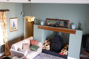 a living room with a fireplace with a couch and a chair at Hill House Lodge sleeps 6 Overlooking the rock of Cashel in Cashel