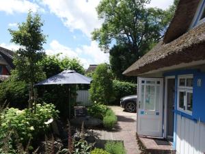 Una pequeña cabaña con sombrilla y patio. en Captain House South Cats 8, en Wieck