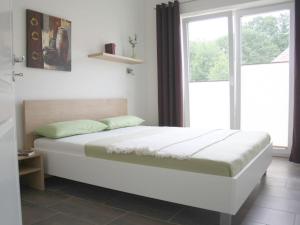 a bed in a room with a large window at Luxury holiday house "Schleibrise" in Hestoft