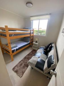 ein Schlafzimmer mit zwei Etagenbetten und einem Fenster in der Unterkunft Hermoso departamento full equipado in Coquimbo