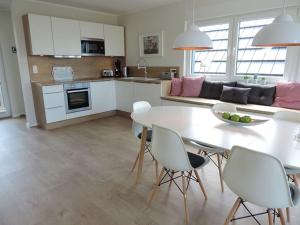a kitchen and living room with a white table and chairs at Penthaus an der Harle in Carolinensiel