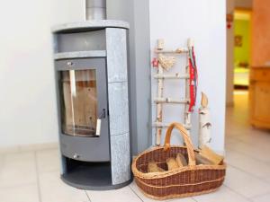 a wood burning stove with a basket and a shelf at Holiday apartment in the rose garden in Birach +22 photos