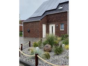 a brick house with a garden in front of it at Holiday home Ankerherz in Butjadingen