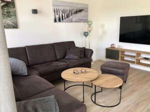 a living room with a couch and a table at Holiday home Ankerherz in Butjadingen