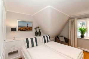 una camera bianca con un letto e un faro di LITZKOW 16204 ad Archsum